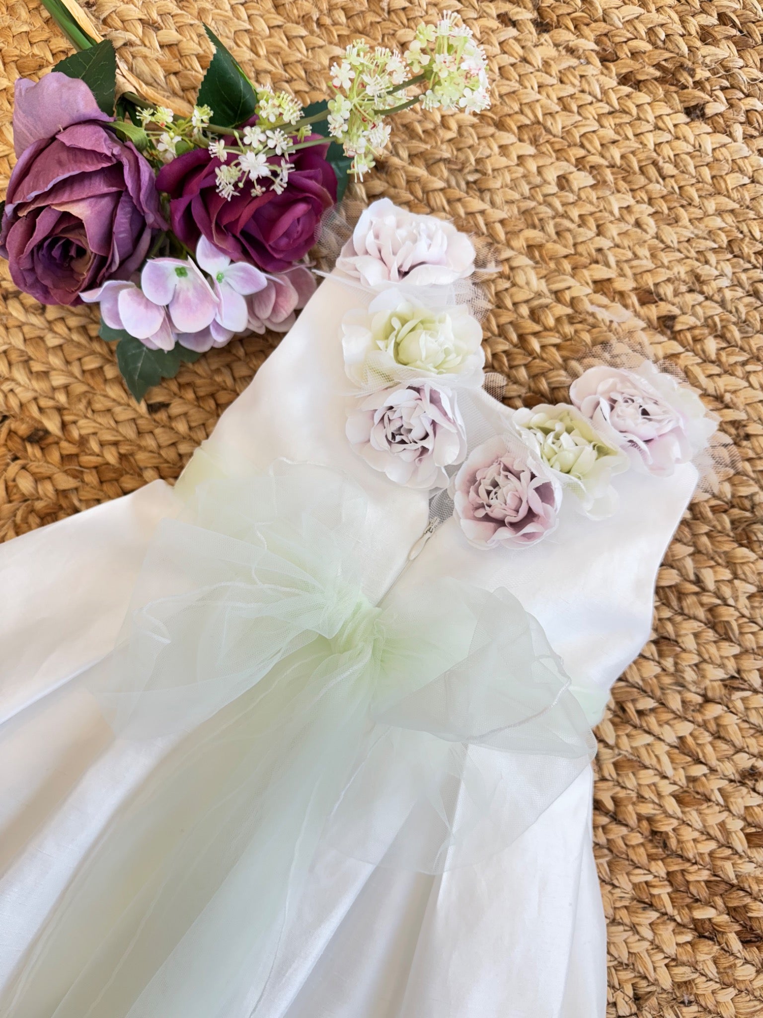 Retro dell'abito da Battesimo bimba con decorazioni floreali e fiocco in tulle.