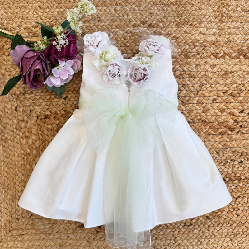 Abito da Battesimo per bambina con dettagli floreali e cintura verde pastello.