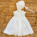 Abito battesimo bimba bianco in tulle con ricamo nido d’ape e cuffietta coordinata