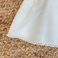 Dettaglio gonna in tulle bianco con pois tono su tono