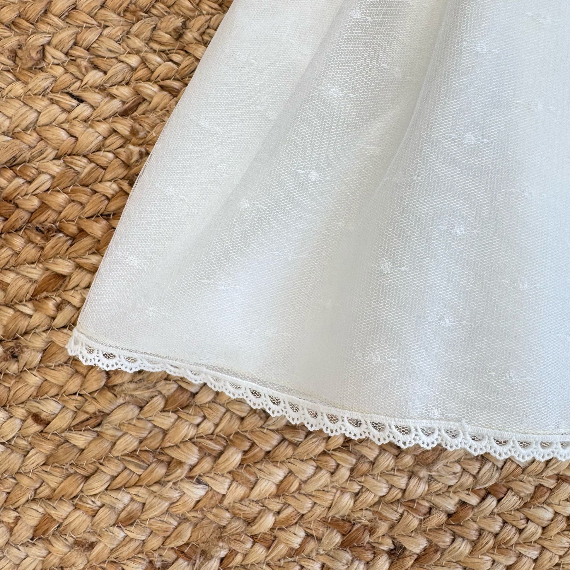 Dettaglio gonna in tulle bianco con pois tono su tono