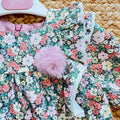 Abito bimba floreale con volant, pompon rosa e fiocco posteriore
