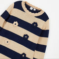 Abito bimba blu e beige in maglia a righe con fiori applicati indossato