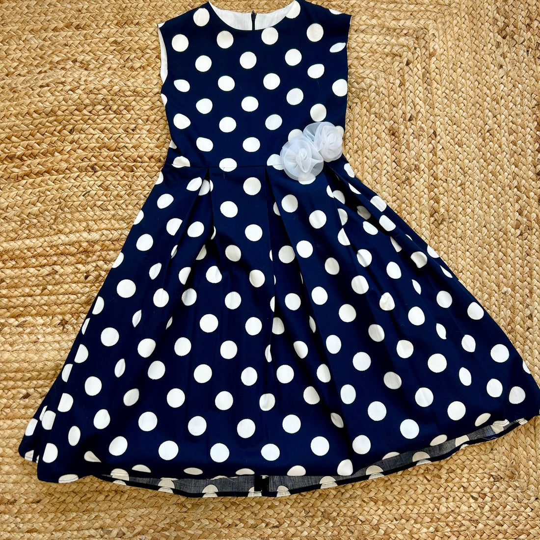 Abito elegante bimba a pois bianchi su fondo blu