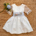 Abito damina bambina azzurro polvere con fiori, tulle plumetis e fiocco sul retro.