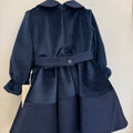 Abito elegante bimba blu in velluto con colletto arrotondato, maniche lunghe e tre fiori decorativi sul punto vita.