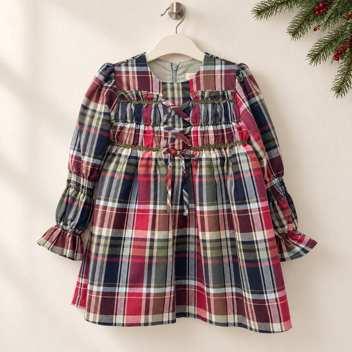 Abito natalizio bambina in misto cotone tartan scozzese rosso, blu e verde, con fiocchi frontali, maniche lunghe e gonna arricciata.