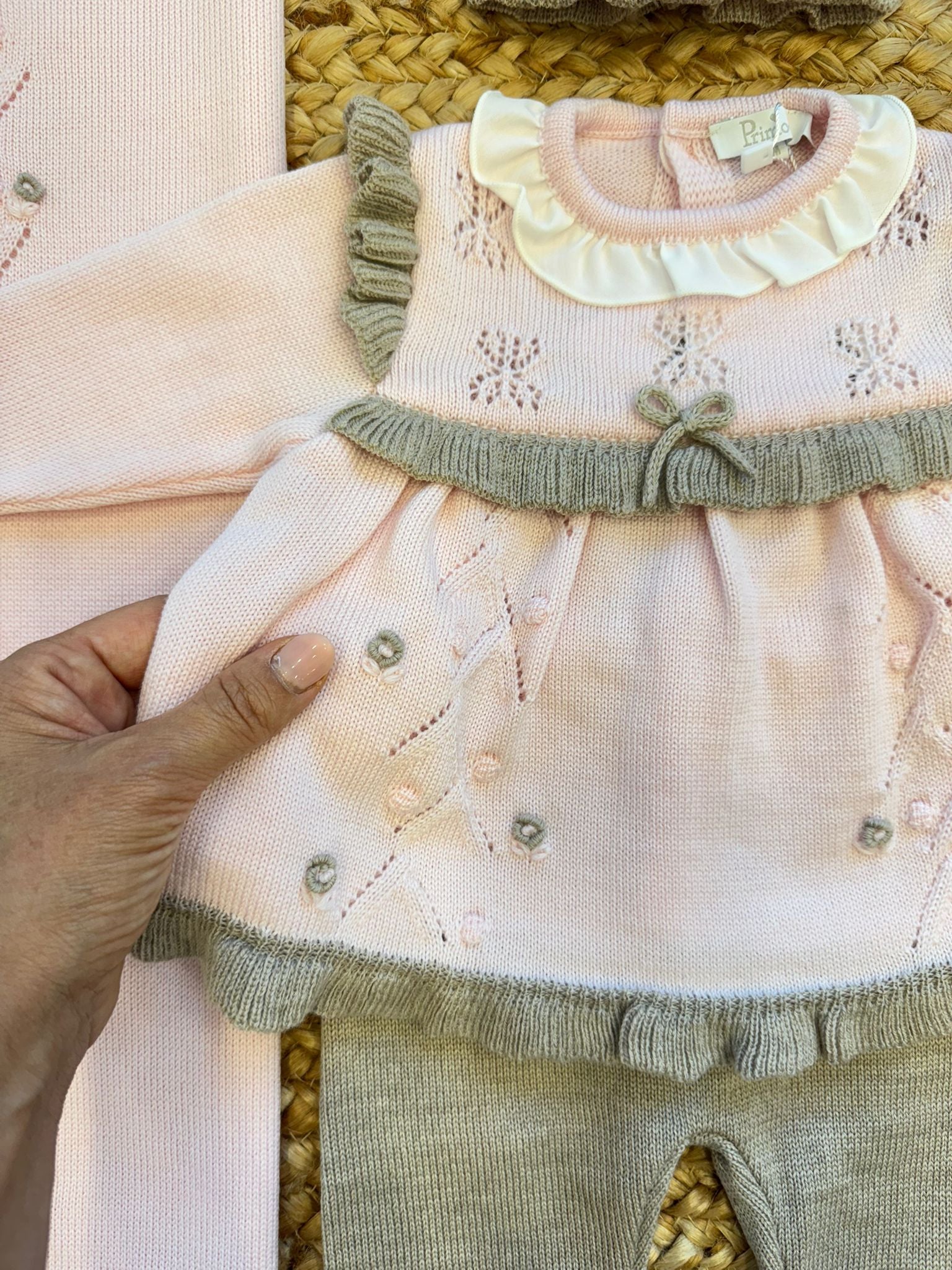 dettaglio abito neonata rosa con ricamo a mano e volant grigi