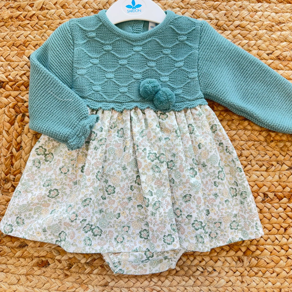 Abito pagliaccetto bimba verde Sardon con fantasia floreale e pompon