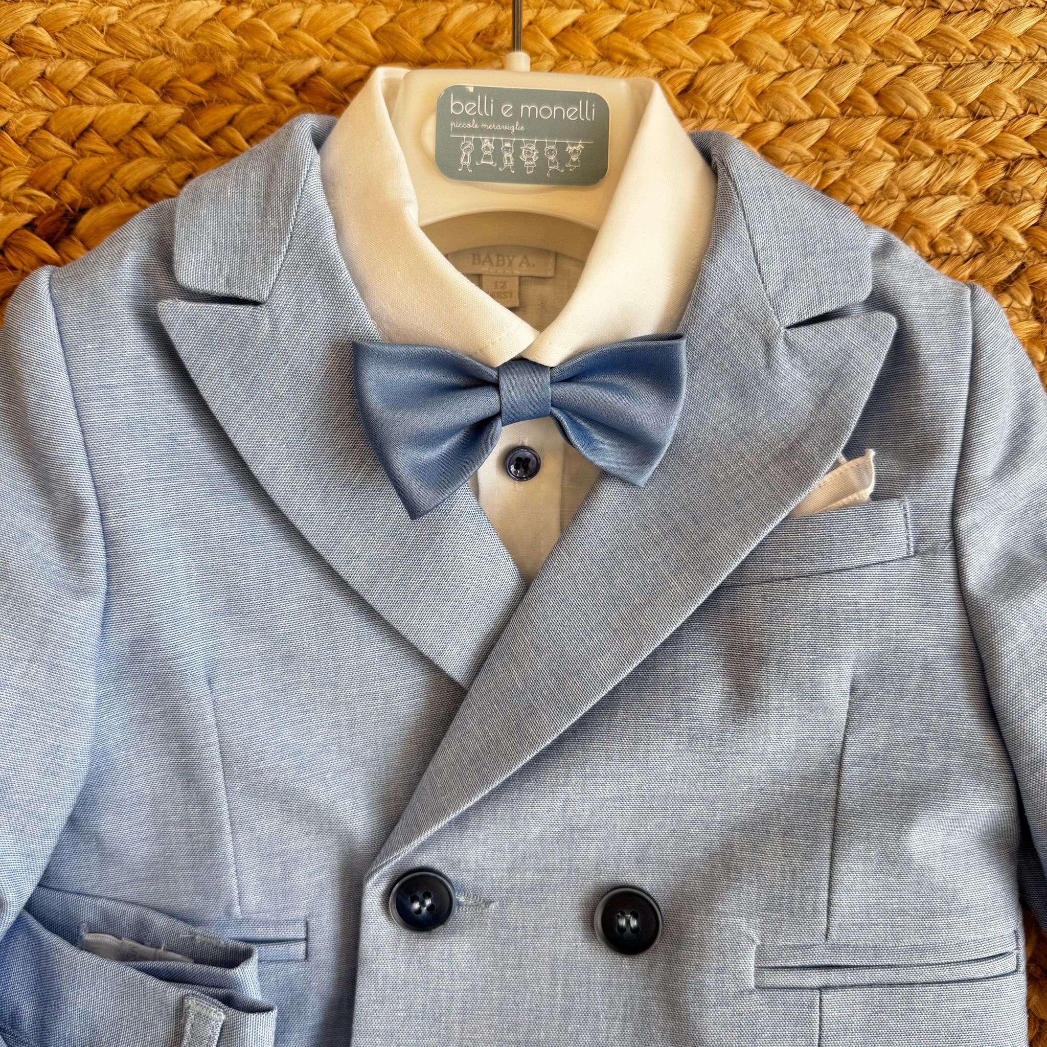 Dettaglio della giacca doppiopetto con papillon in raso azzurro.
