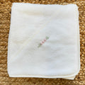 Accappatoio neonata in spugna color latte con cappuccio e roselline rosa ricamate