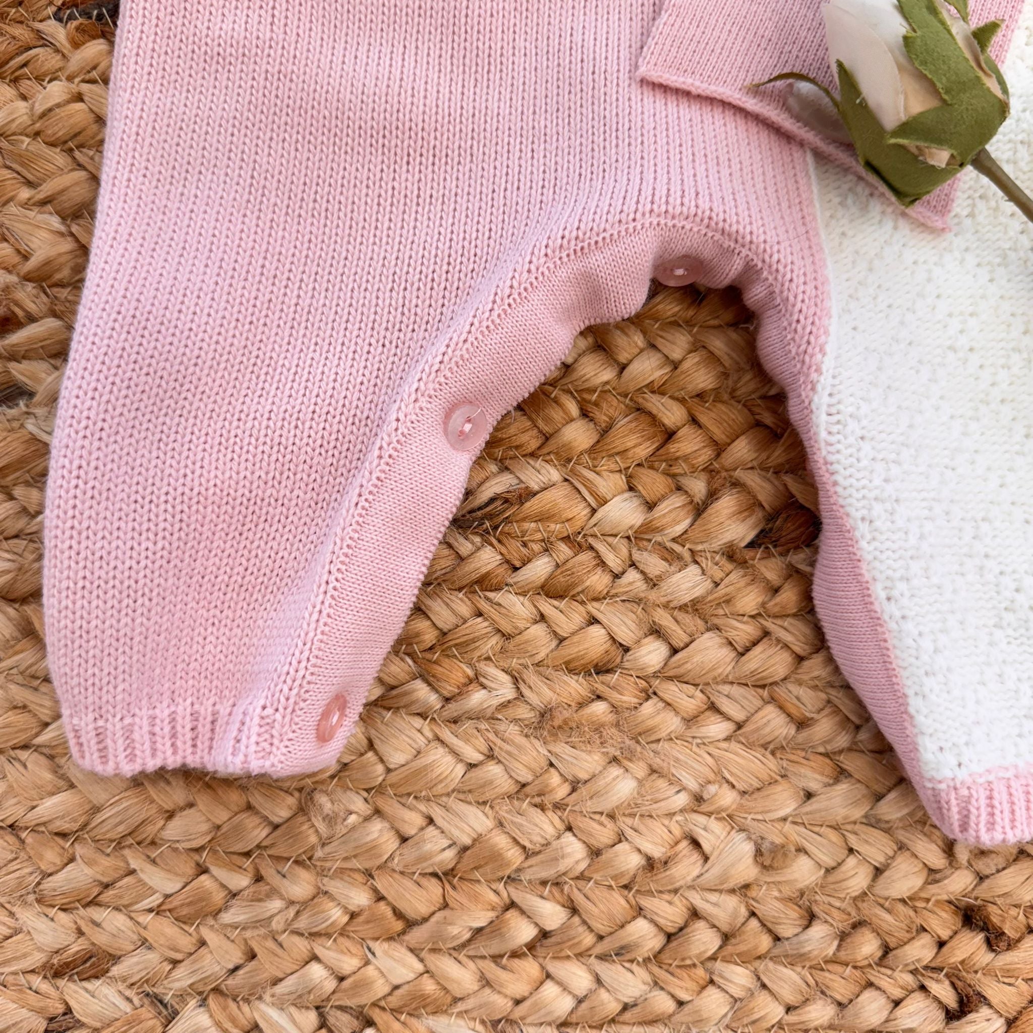 Apertura con bottoni tra le gambe nella tutina rosa e panna per neonata