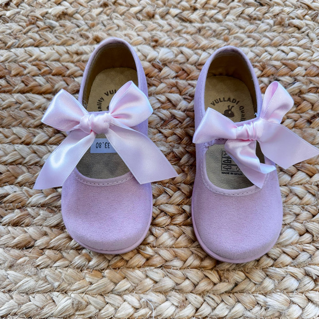 Ballerine rosa in camoscio con fiocco in raso, perfette per cerimonie ed eventi speciali.