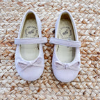 Ballerine taupe in camoscio per bambina con cinturino e fiocco decorativo, perfette per cerimonie ed eventi speciali.