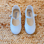 Ballerine bianche in tessuto per bambina con cinturino e fibbia laterale, ideali per cerimonie e occasioni speciali.