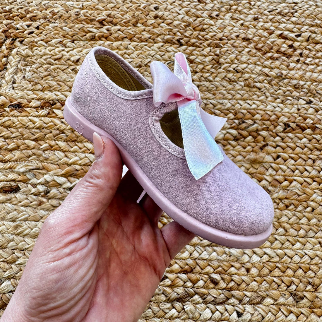 Ballerine rosa in camoscio con fiocco in raso, perfette per cerimonie ed eventi speciali.