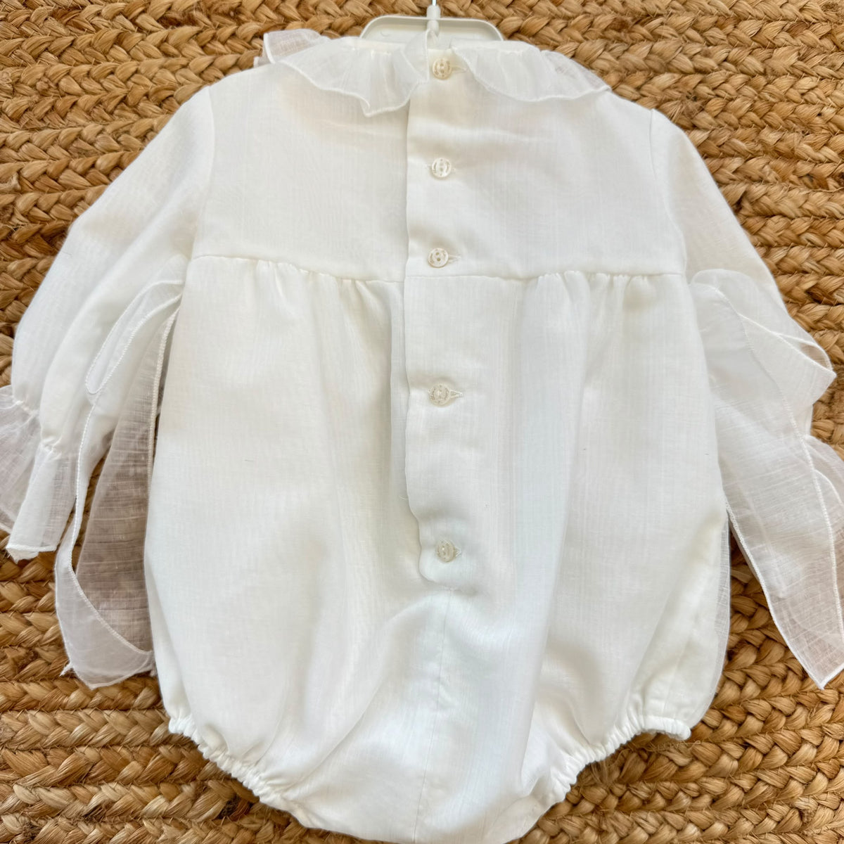 Pagliaccetto battesimo bimba avorio con punto smock, ricami beige e volant
