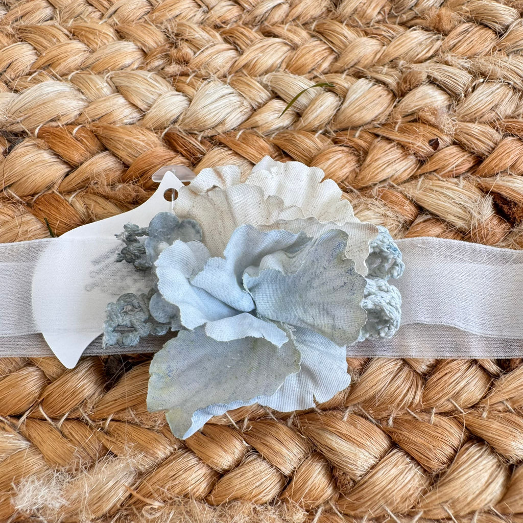 Fascetta battesimo bambina con fiori azzurri su nastro elastico bianco