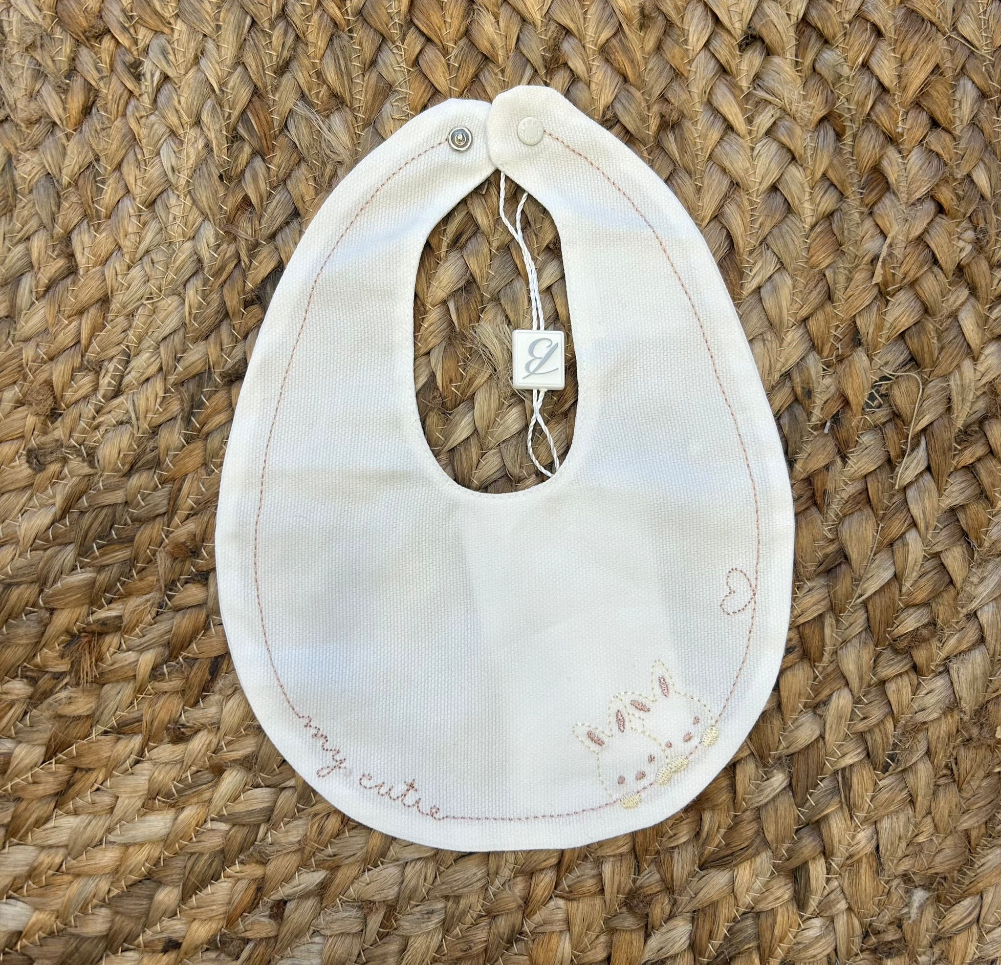 Bavaglino elegante per neonata con ricamo coniglietti, cuore e scritta "my cutie" in cotone panna.

