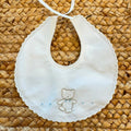 Bavaglino neonato in 100% cotone bianco con ricamo orsetto e bordo smerlato.
