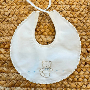 Bavaglino neonato in 100% cotone bianco con ricamo orsetto e bordo smerlato.