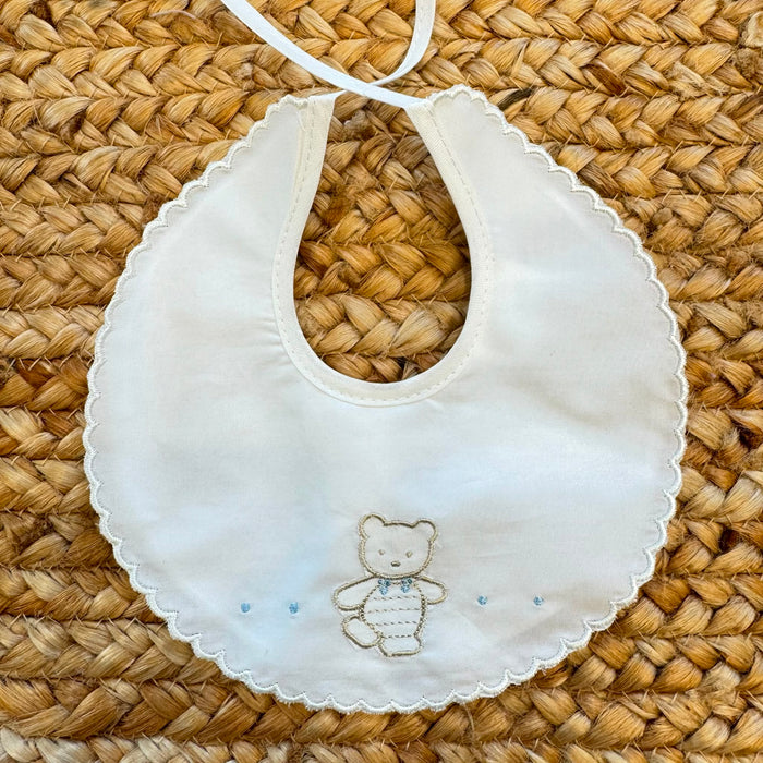 Bavaglino neonato in 100% cotone bianco con ricamo orsetto e bordo smerlato.