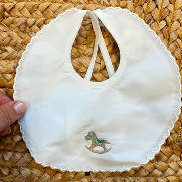 Bavaglino neonato in 100% cotone bianco con ricamo cavallino e bordo smerlato elegante.