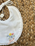 Bavaglino bianco con ricami floreali e fiocco rosa cipria