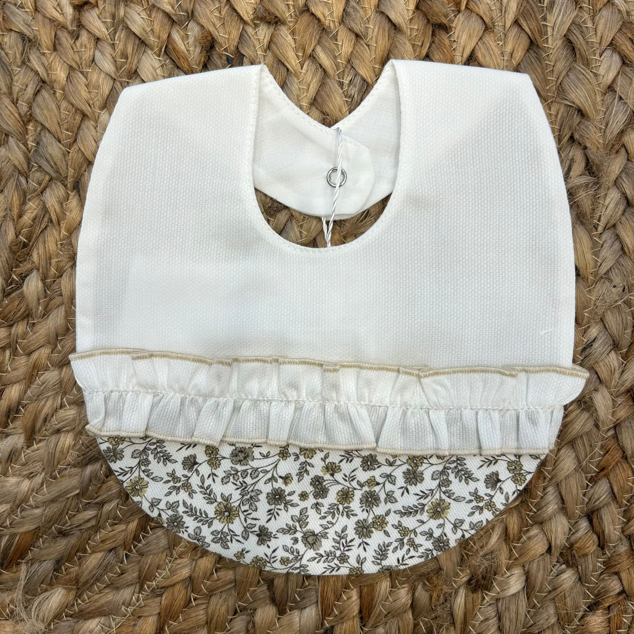 Bavaglino neonata con volant in cotone rigato panna e tessuto floreale beige.

