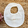 Bavetta neonata in ciniglia color latte con rosellina rosa ricamata – corredino nascita