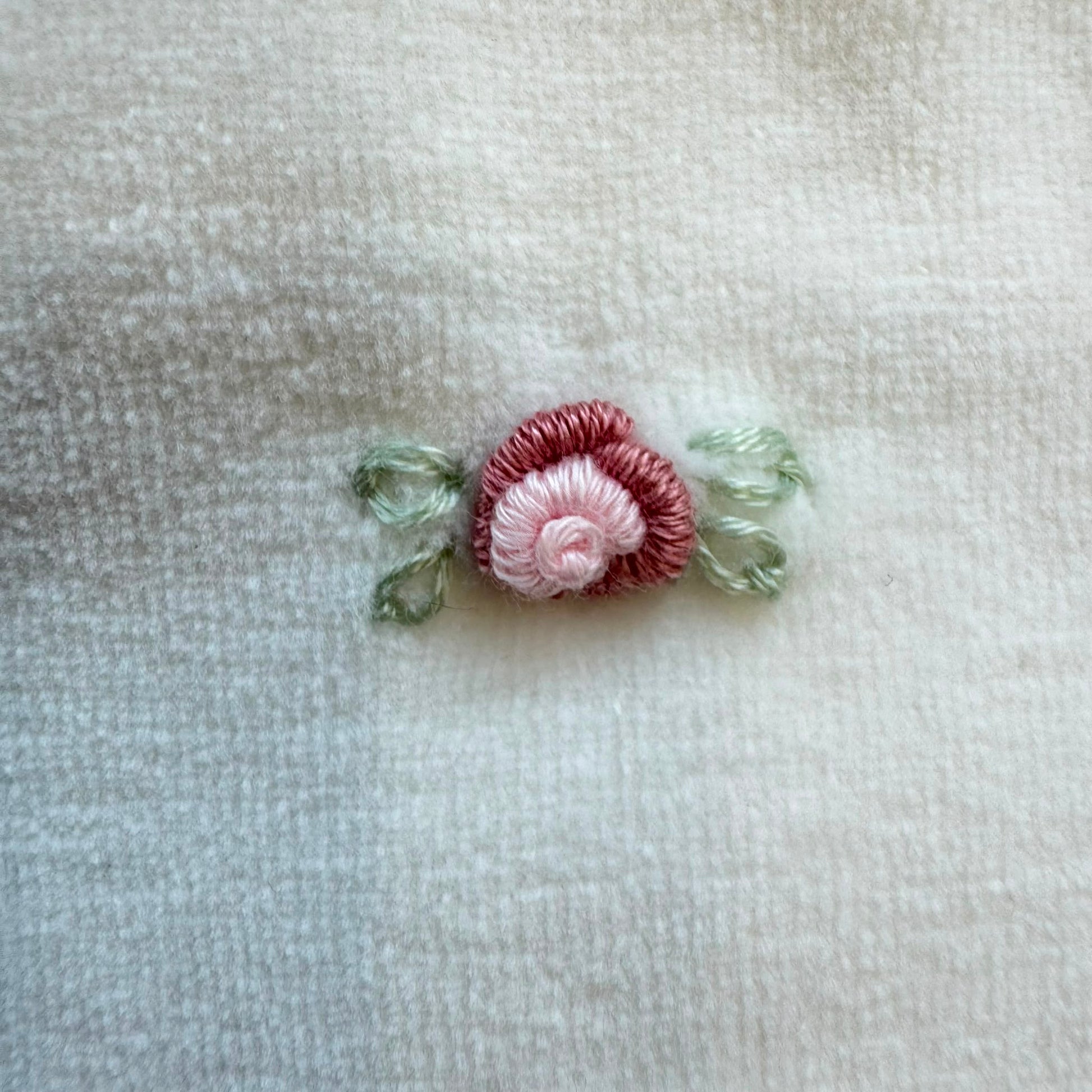 Bavetta neonata in ciniglia color latte con rosellina ricamata rosa antico