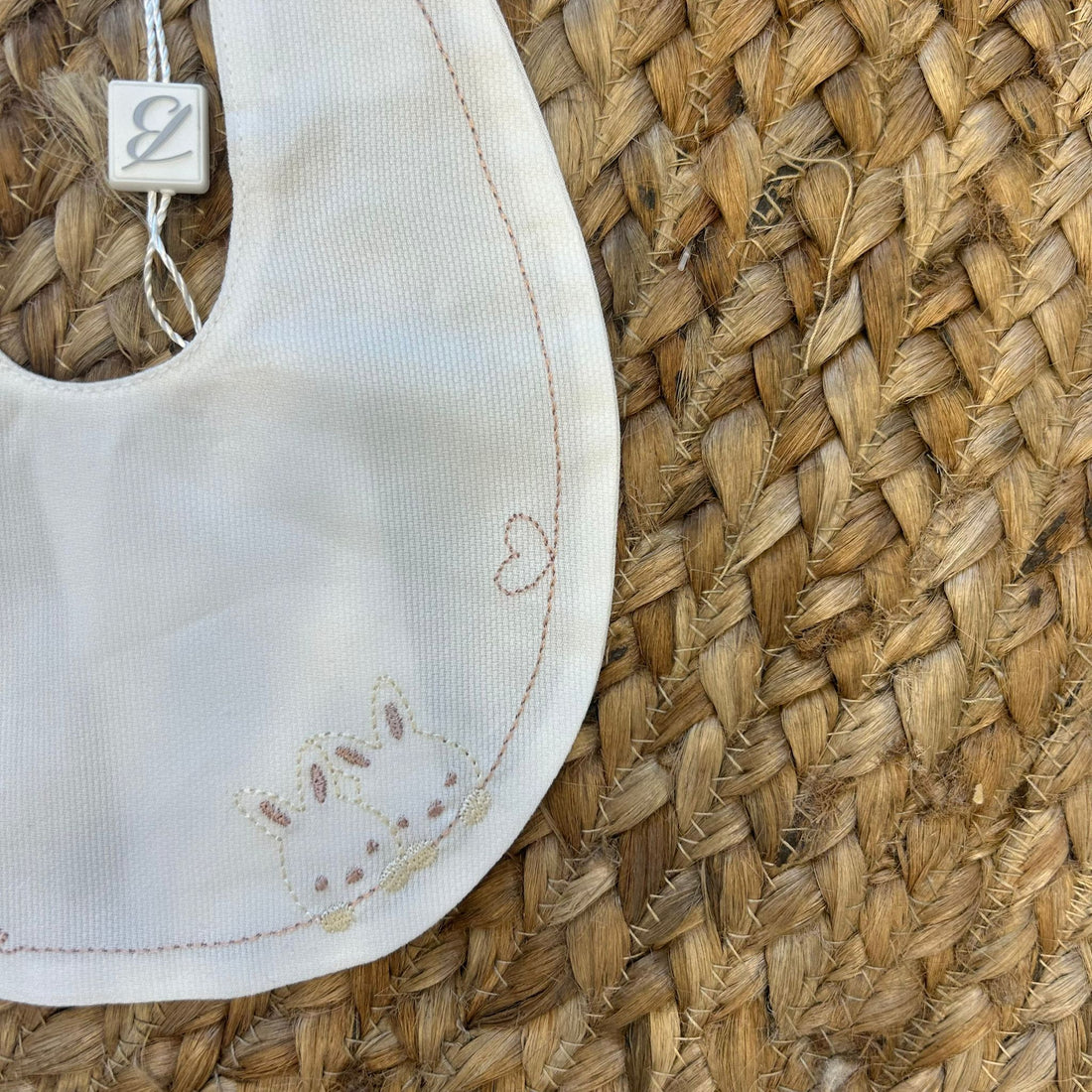 Bavaglino elegante per neonata con ricamo coniglietti, cuore e scritta "my cutie" in cotone panna.

