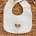 bavetta neonato panna con cuore ricamato a mano rosa cipria