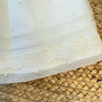Orlo con pizzo ricamato e pois su abito cerimonia neonata