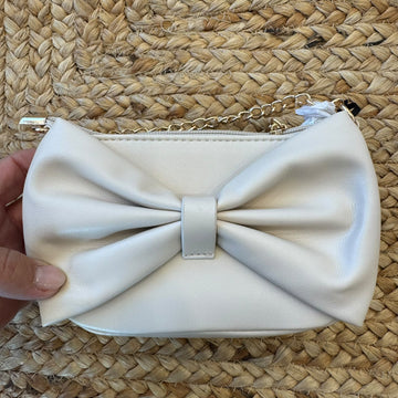 Borsa a tracolla bimba beige con grande fiocco frontale e catena dorata.