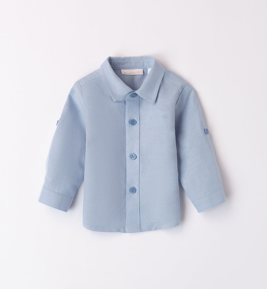 maglione bianco con camicia blu e pantaloni beige per bambino, con dettagli in blu e camicia azzurra in lino. perfetto per un look elegante e casual.
