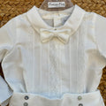 Completo battesimo neonato bianco con camicia a maniche lunghe decorata in pizzo floreale, papillon e pantaloncino a palloncino.