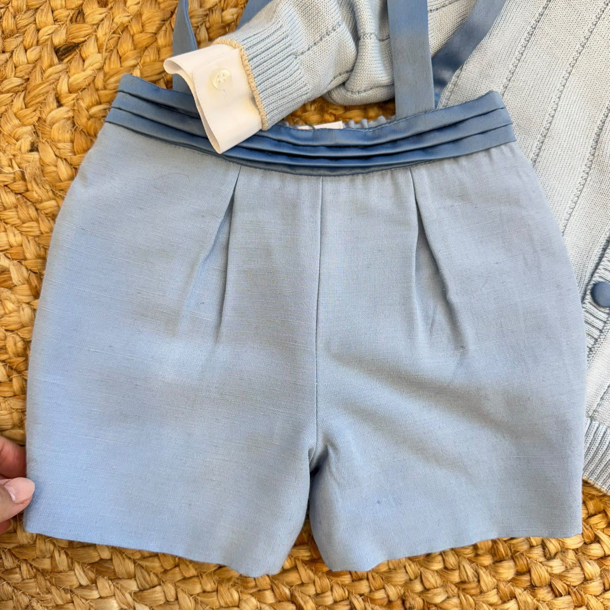 Cardigan azzurro del completo battesimo bimbo con camicia bianca e papillon fantasia.
