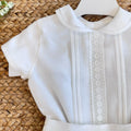 Dettaglio camicia bianca bimbo con ricami tono su tono

