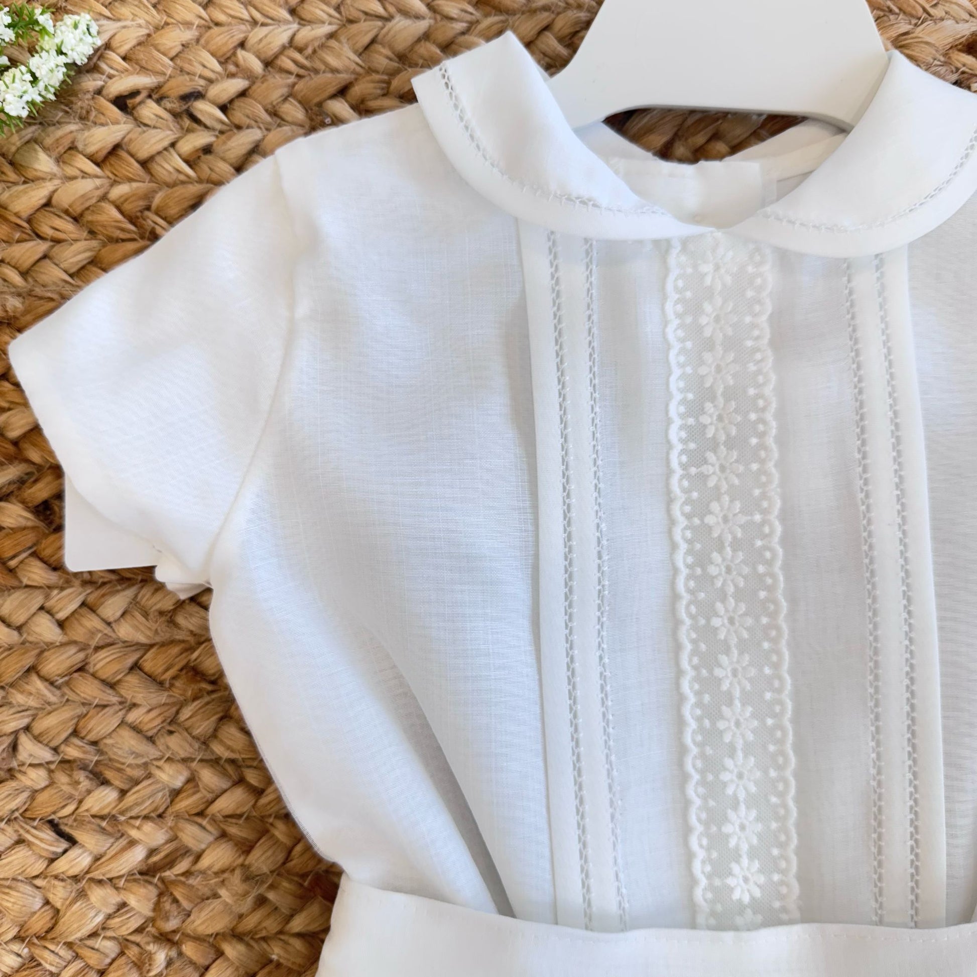Dettaglio camicia bianca bimbo con ricami tono su tono

