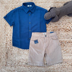 Camicia in lino blu e pantaloncini in cotone beige per bambino, abbigliamento estivo casual.