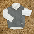 camicia bimbo bianca con gilet grigio appoggiati su tappeto