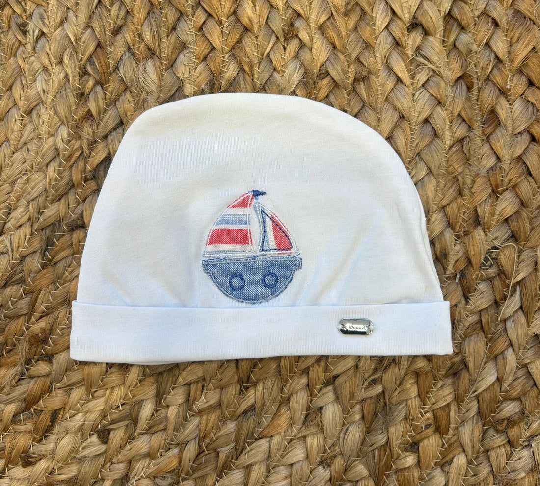 Cappellino neonato bianco con barca a vela applicata in denim e rosso.