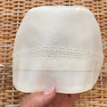 Cuffietta battesimale unisex bianca con ricamo decorativo e laccetti in raso.