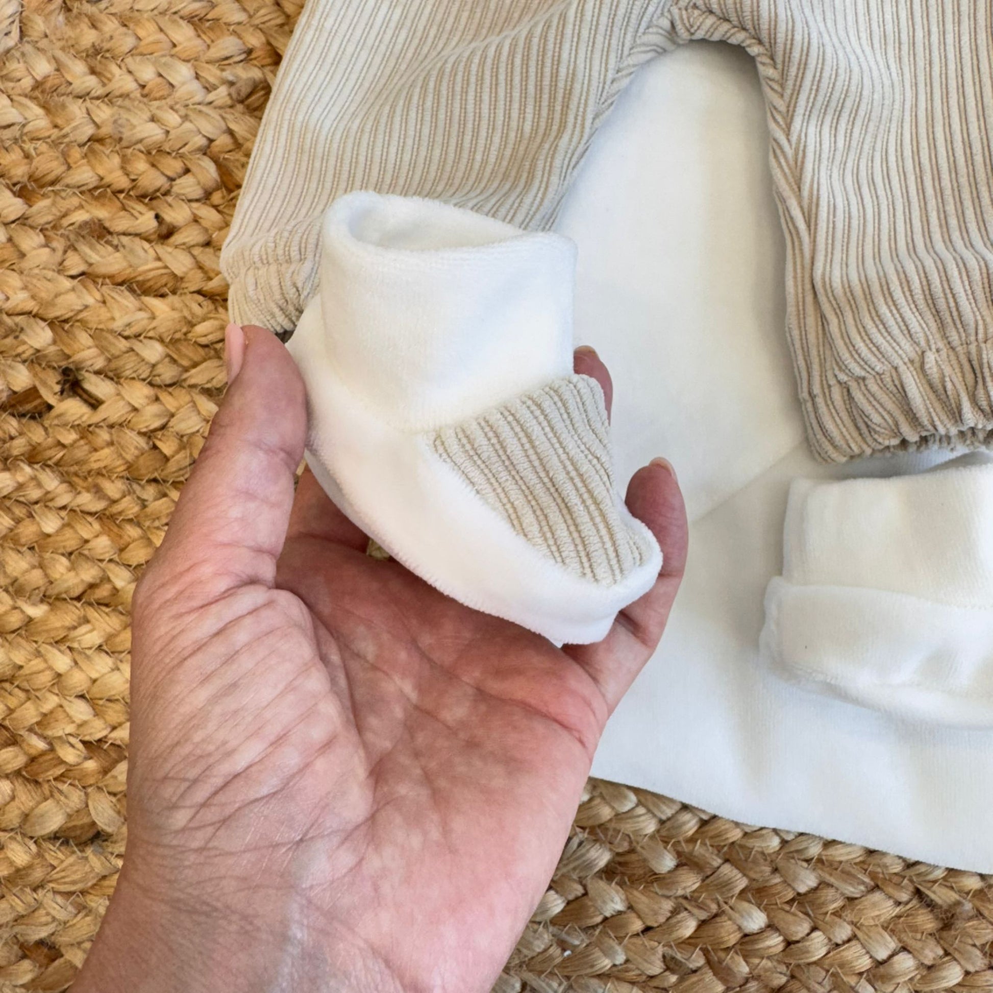 	Cappellino beige in cotone abbinato al coordinato neonato
