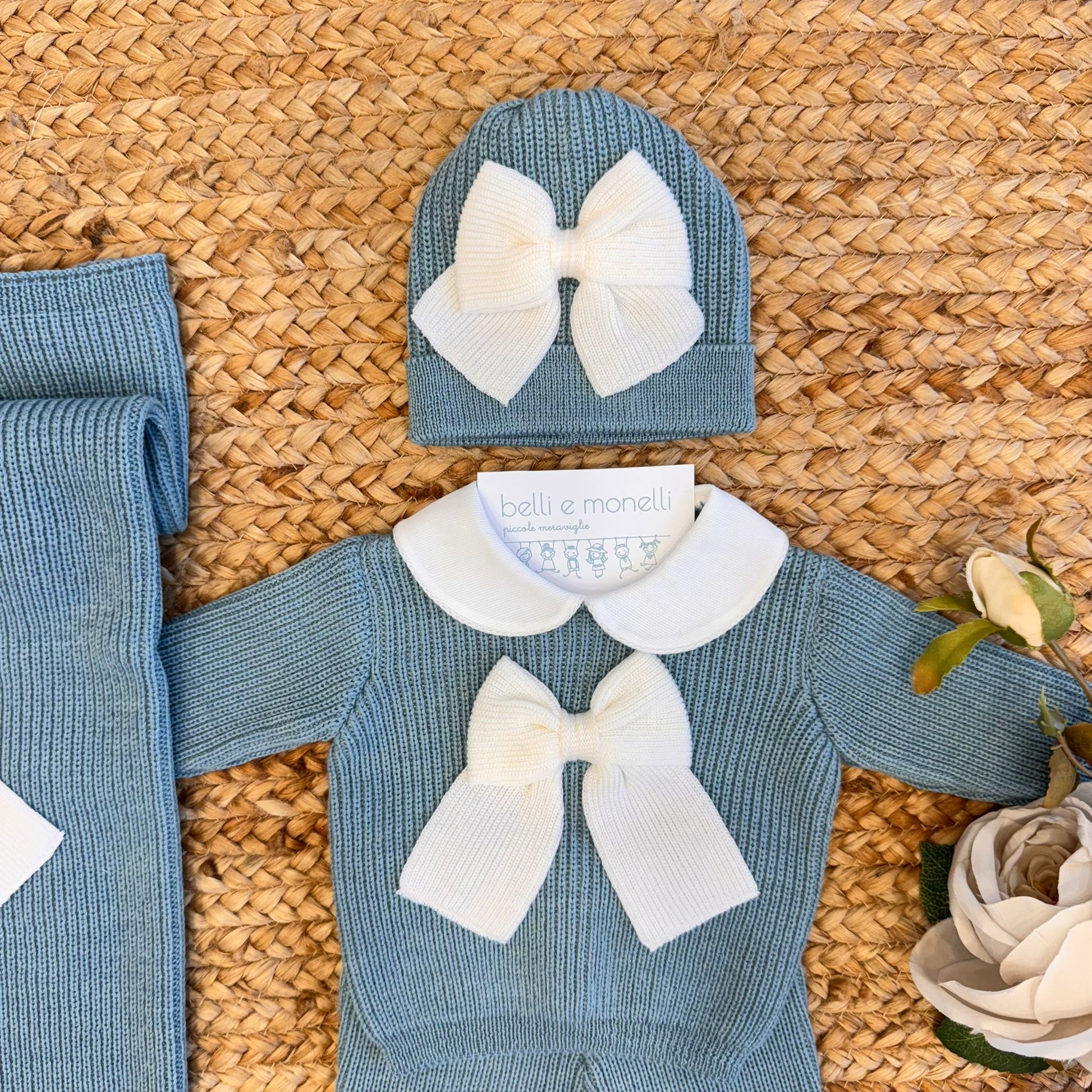 Dettaglio fiocco panna sul cappellino neonato in lana