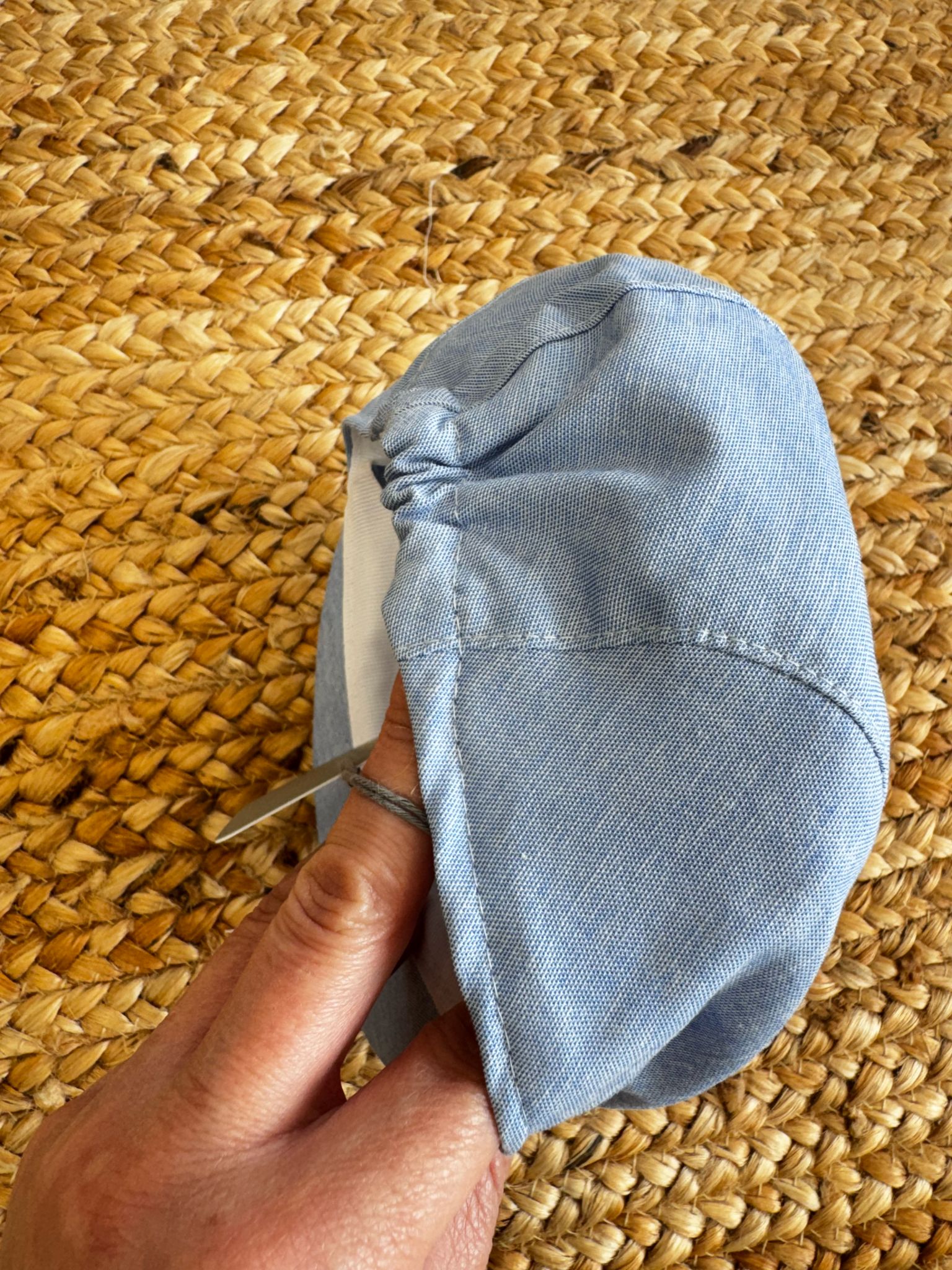 Cappellino in lino azzurro con elastico posteriore per battesimo e cerimonia, vista posteriore