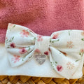 Cappellino neonata in ciniglia malva e panna con fiocco floreale per corredino nascita