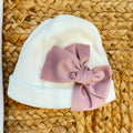 Uscita clinica neonata in ciniglia panna con ricamo floreale a cuore e fiocco rosa composta da tutina, bavetta, cappellino, lenzuola coordinate e copertina sfoderabile.