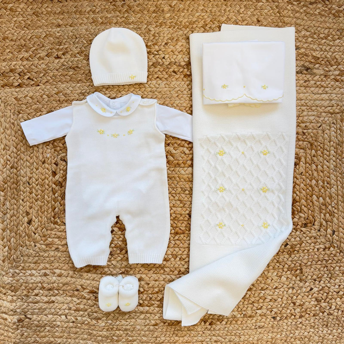 Uscita clinica neonata in pura lana bianco latte con tutina, copertina, cappellino e scarpette con fiorellini gialli.